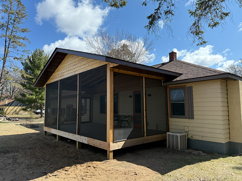 kvl-construction-gallery-23 New screened-in porch with wood framing and gable roof added to single-story home, creating a shaded outdoor living space.